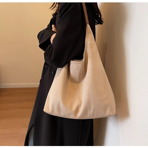 Detailed view of beige suede hobo bag featuring premium texture and brown shoulder strap
