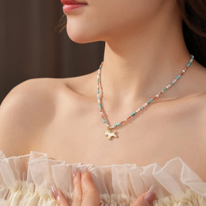 Detail of beaded unicorn necklace with mother of pearl pendant and colorful rice beads