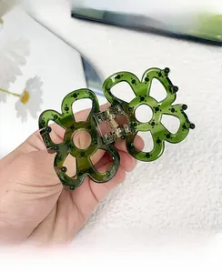 Detailed view of hollow five-petal flower hair claw in dark green acetate resin finish
