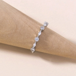 Macro detail of a silver ring with marquise and round cubic zirconia on a wooden stand