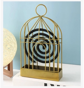Detailed view of birdcage metal incense holder in gold finish with hanging ring and tray