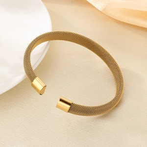 Dettaglio del bracciale rigido a rete intrecciata placcato oro 18 carati su piatto bianco