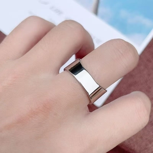 Close-up of polished silver wide band bottle opener ring on hand with mirror finish