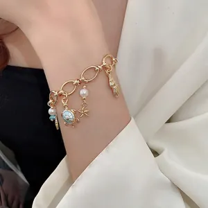 Golden ocean theme charm bracelet with starfish, turtle and pearls for summer vacation