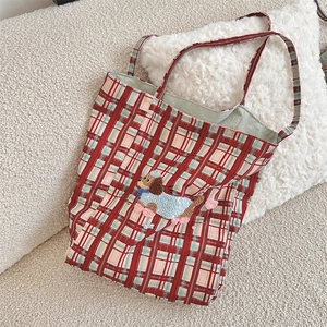 Close-up of red plaid canvas tote bag featuring a 3D plush puppy embroidery detail