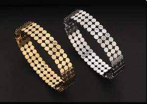 Détail de bracelets en maille plaqué or 18 carats et argent avec motif à pois