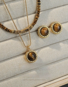 Detail of vintage tiger eye stone jewelry set including necklace and stud earrings