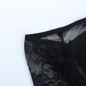Close-up of intricate black lace patterns and delicate mesh texture on the corset top