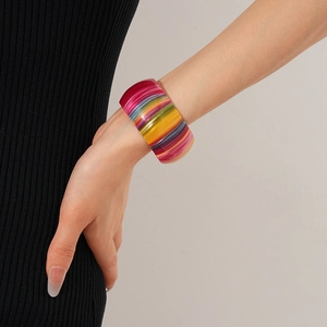 Detail shot of a wide open cuff bracelet with vibrant colorful acetate stripes on wrist