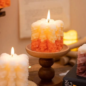 Halloween skull candle with orange gradient finish on a rustic wooden stand