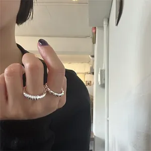Detail of 925 sterling silver rings with twisted rope and hammered textures worn by a model