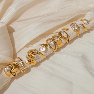 Detailed arrangement of gold-plated rings with cubic zirconia on elegant silk fabric