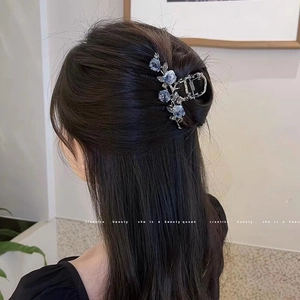 Pince à cheveux française élégante avec camélias bleus sur coiffure demi-attachée