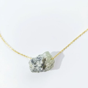 Irregular natural raw gemstone crystal pendant necklace with gold chain on white background