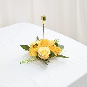 Detailed close-up of a golden candle holder with yellow and orange artificial rose wreath