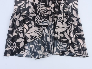 Detailed view of layered chiffon hem with leaf print and wavy ruffled edge finish