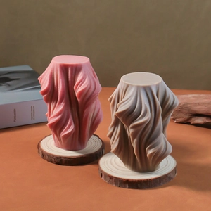 Spiral pleated geometric candle mold and finished sculptures on natural wood base