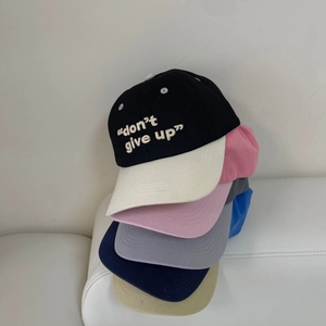 Primer plano de gorras de béisbol bordadas en varios colores con texto de motivación