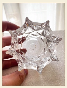Macro-opname van glazen kandelaar met diamanttexturen en stervormige gekartelde rand