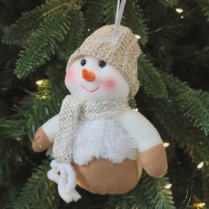 Christmas snowman plush ornament hanging on a pine tree with warm knit textures