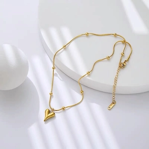 Detail of gold heart pendant with fine snake chain and S925 sterling silver stamp