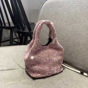 Detail of pink rhinestone handbag on chair showing shimmering crystal texture and handle