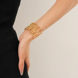 Vue détaillée du bracelet manchette doré multi-rangs porté par un mannequin en noir