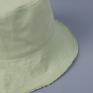 Vue détaillée d'un chapeau bob vert clair avec coutures et texture de tissu en sergé
