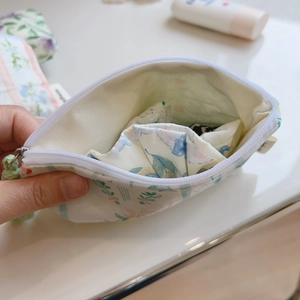 Detail view of cotton floral pouch interior with zipper and soft fabric texture