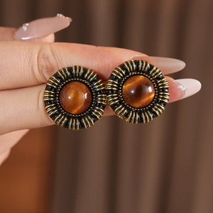 Macro shot of vintage resin heart earrings with bronze gold finish and amber stone detail