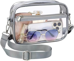 Transparent PVC crossbody bag with grey straps showing internal storage capacity