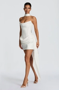 Détail de la mini robe en satin blanc avec décolleté bustier et longue traîne latérale