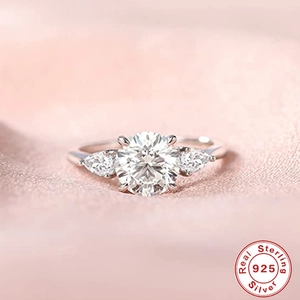 Close-up of 925 sterling silver ring with round diamond and pear-shaped side stones
