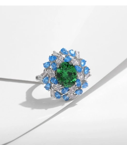 Close-up of vintage s925 silver ring with green emerald-cut zircon and blue accents