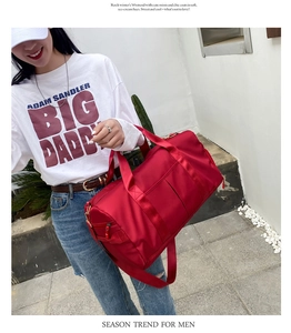 Red large capacity fitness bag with shoulder strap and side zipper pocket shown on model