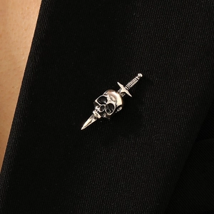 Gothic skull and sword brooch pin in antique silver finish on a black suit lapel