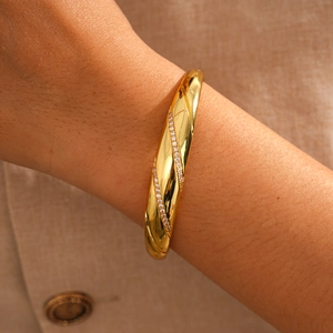 Detail of 18k gold plated bangle with twill texture and shimmering zircon inlay