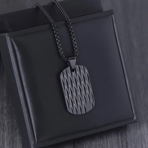 Close-up of black rectangular tag pendant with diagonal texture on gift box