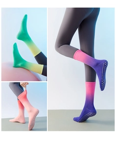 Detail of gradient yoga socks with non-slip silicone grips in pink, orange and green colors