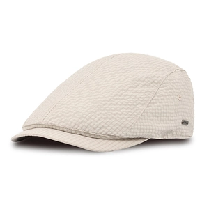 Detail of beige seersucker flat cap showing breathable fabric texture and metal side logo