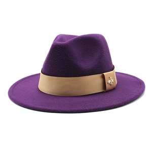 Detailed macro of dark purple wool fedora featuring camel band and golden bee charm