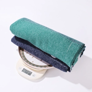 Close-up of thick knitted ethnic shawls in dark green and blue showing heavy texture