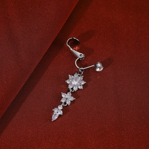 Macro detail of silver heart and cross belly ring with sparkling zircon insets