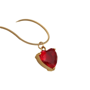Elegant gold snake chain necklace featuring a faceted red heart-shaped crystal pendant