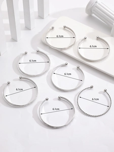 Detail view of 7 pieces silver alloy bangles with 6.1cm diameter and textured designs