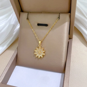 Close-up of golden daisy flower necklace with white zircons in a luxury jewelry box