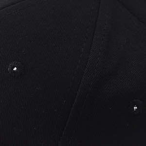 Macro detail of black cotton twill fabric with reinforced stitching and embroidered eyelets