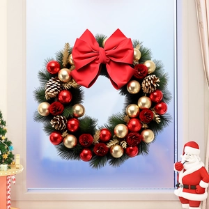 Détail d'une couronne de Noël avec baies rouges et pommes de pin sur fenêtre