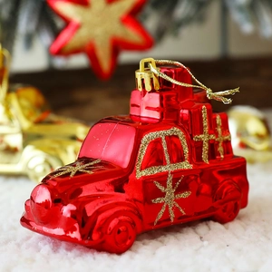 Detail of a red Christmas car ornament with gold glitter accents and a mini gift box