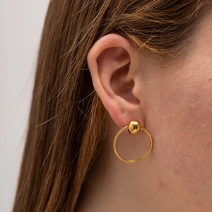 Close-up of a model wearing a gold spherical stainless steel earring for women
